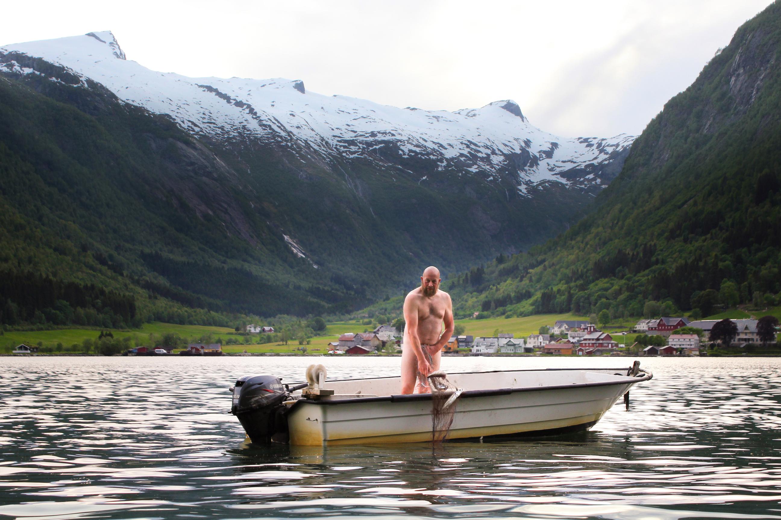 bilete av ein naken mann i båt