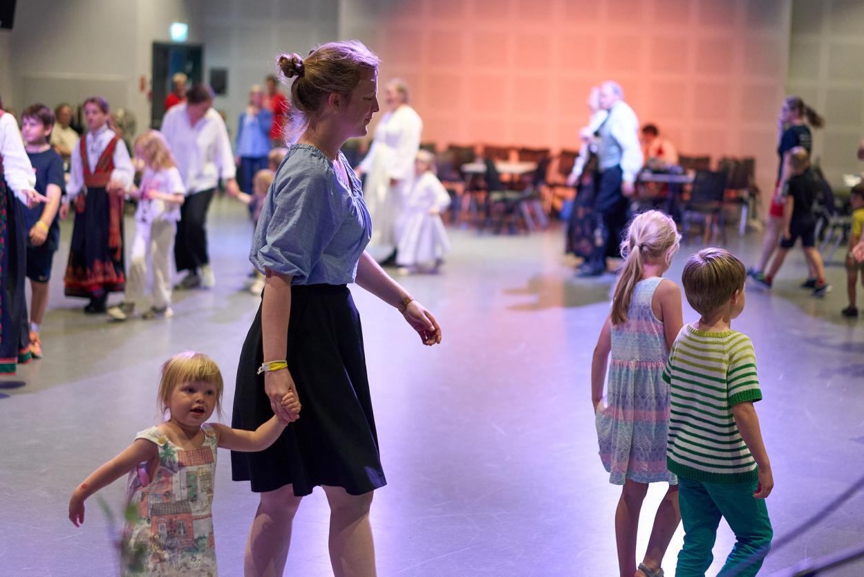 Barn og vaksne som dansar i lag