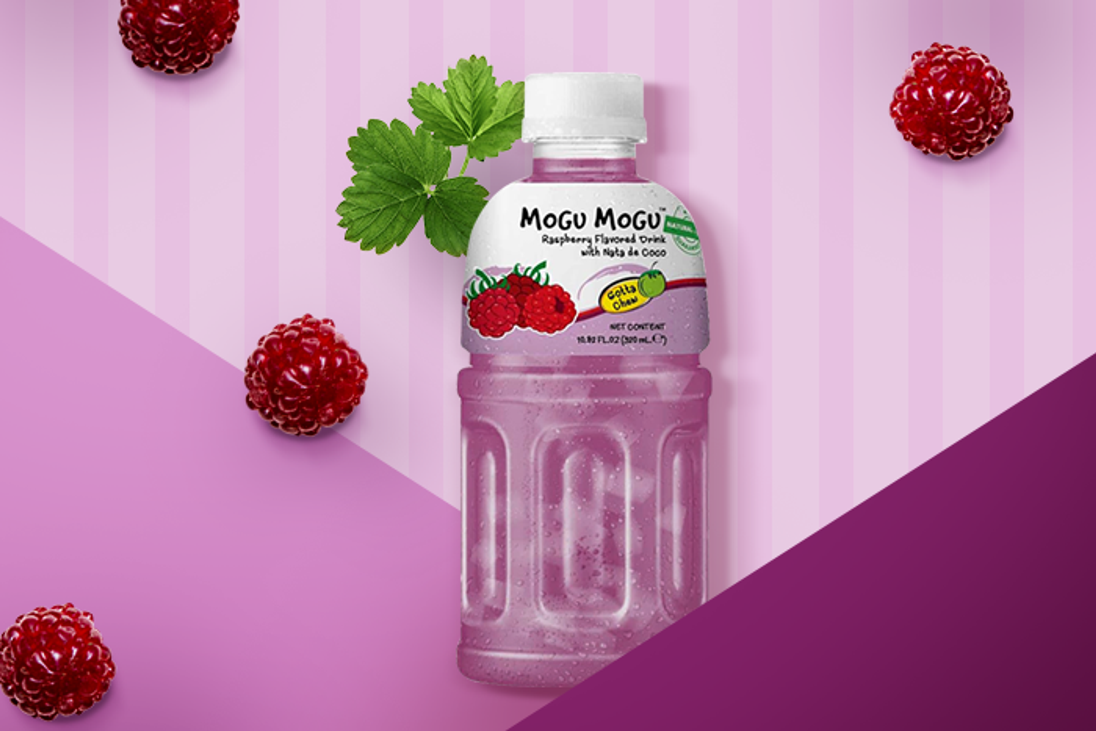 Flasche Mogu Mogu, umgeben von frischen Himbeeren auf einem sommerlichen Tisch.