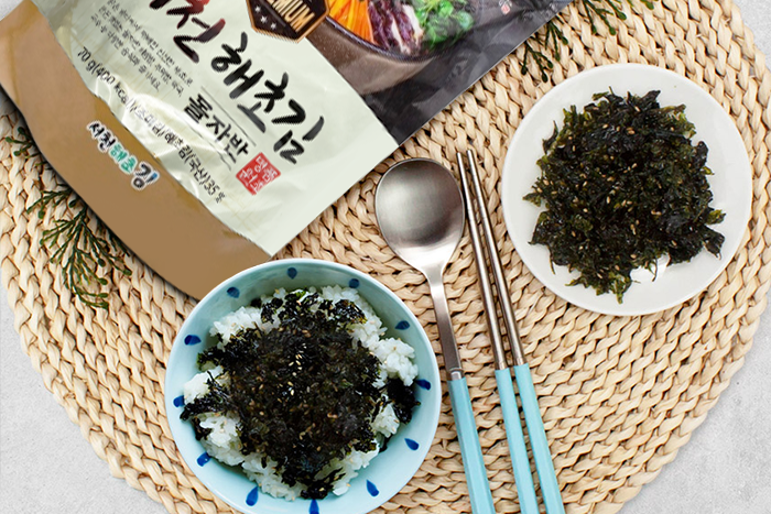 Gesunde-Suppenzutat, Seocheon-Algenflocken schwimmend auf einer klaren asiatischen Brühe