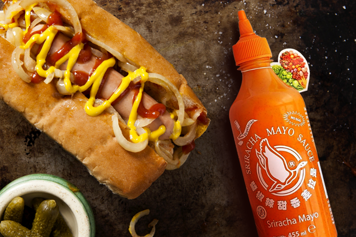 Hand-hält-geöffnete-Flasche-von-FLYING-GOOSE-Sriracha-Mayo-mit-herausfließender-cremiger-Sauce