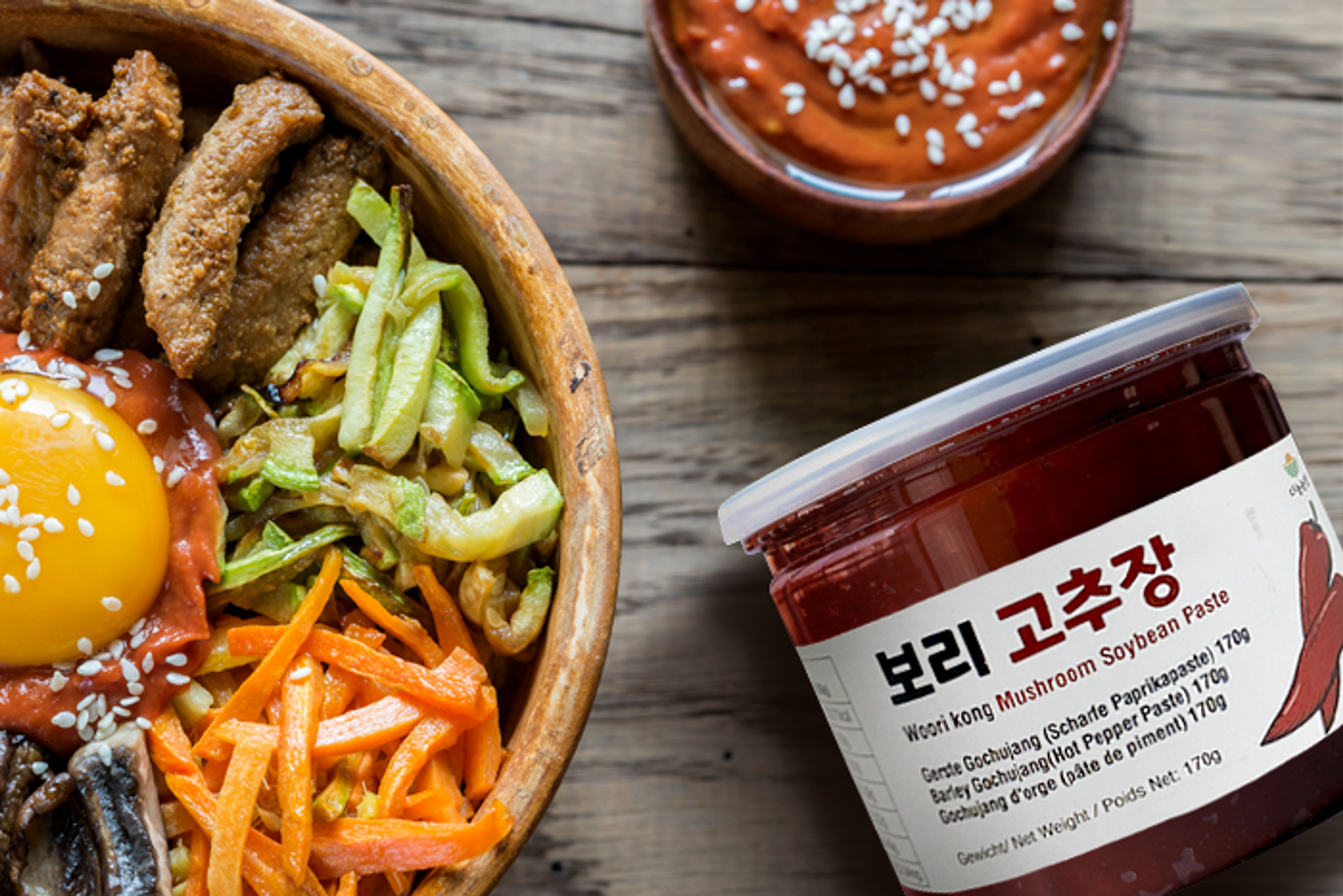 Koreanischer Bibimbap angereichert mit einem Löffel Danong Farm Gerste Gochujang, betont die Verwendung in traditionellen Gerichten.