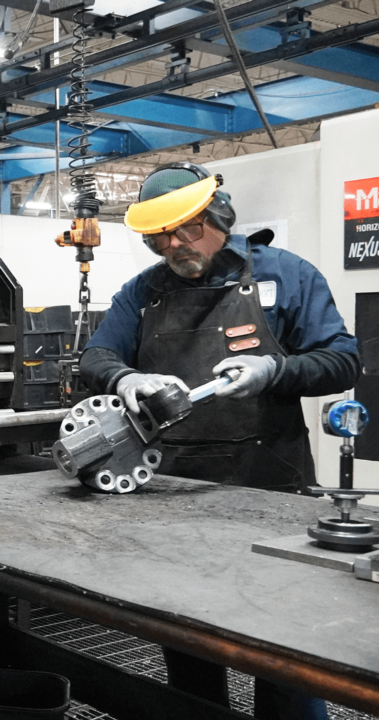 An operator working at a workbench in a busy, professional machine shop