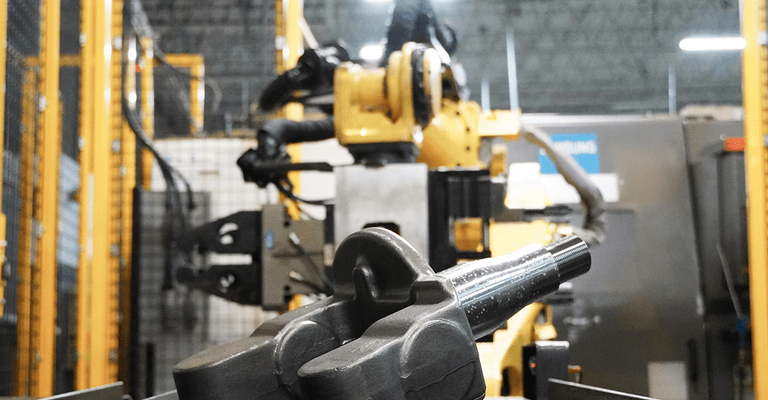 A yellow robotic arm lift mechanism handling component on a conveyor