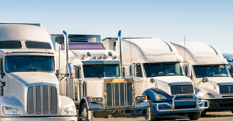 Lineup of commercial semi-trucks parked side-by-side