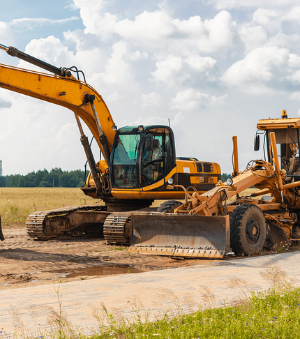 Industrial excavator and heavy machinery parked on a dirt worksite