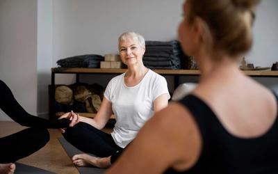 Femme en séance de yoga et méditation, assise en tailleur dans un environnement calme, illustrant la recherche de bien-être et d’équilibre entre le corps et l’esprit.