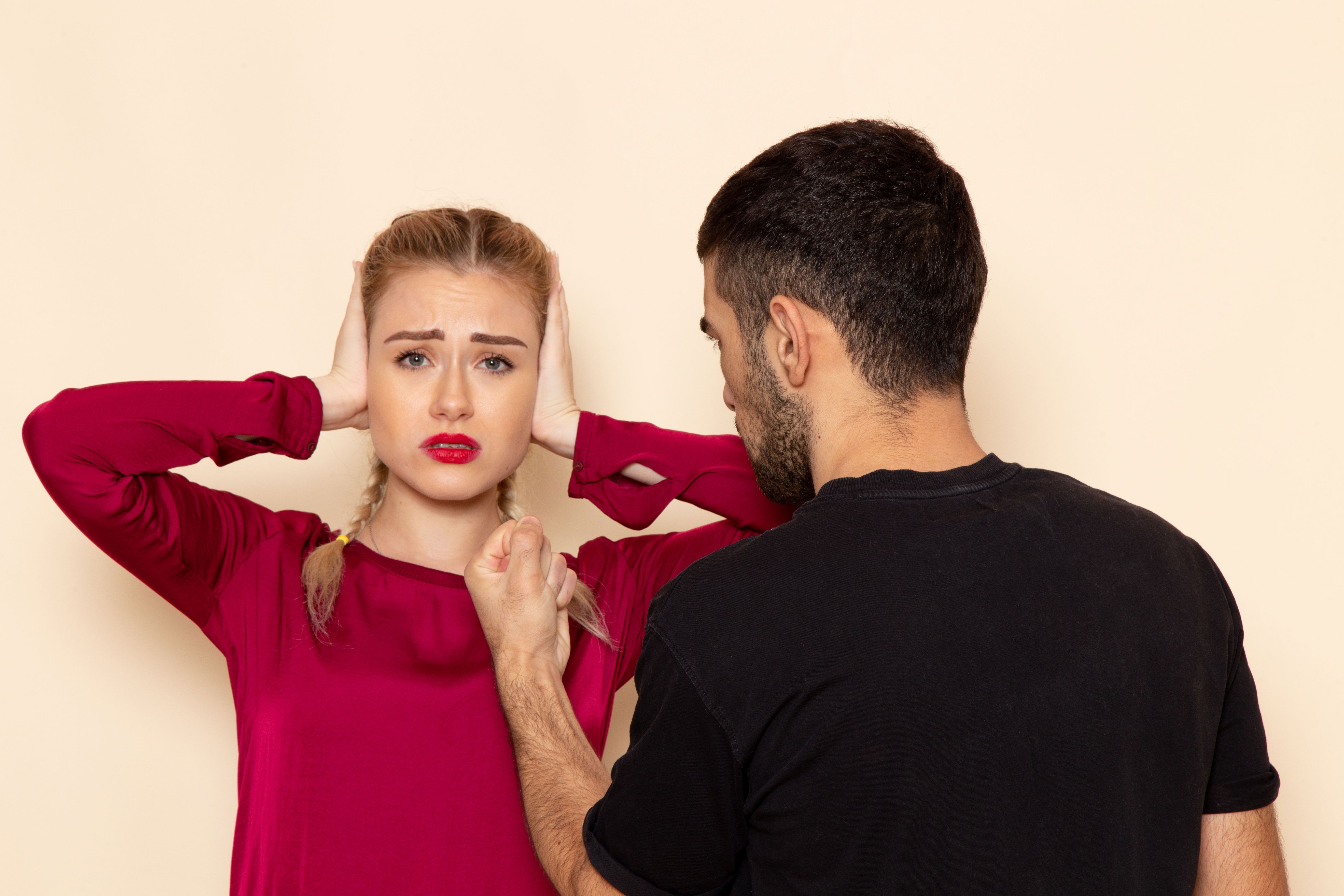 Femme en détresse face à un homme agressif, illustrant l’emprise et la violence psychologique d’un pervers narcissique.