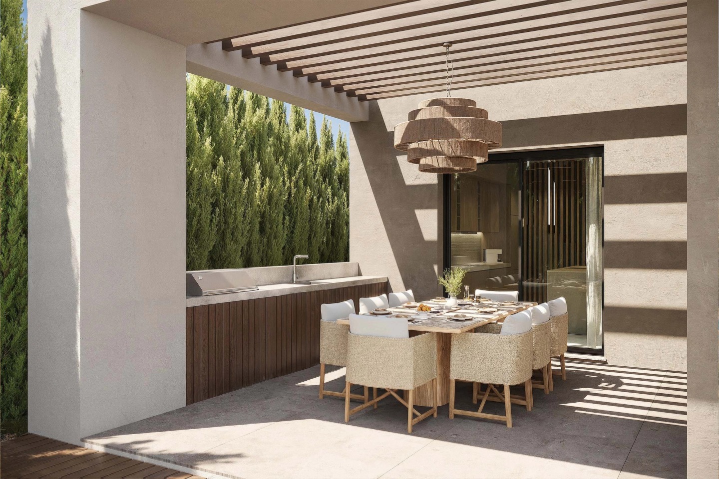 Outdoor dining area under a pergola, with an outdoor kitchen and a woven pendant lamp, at Pearl Villas.