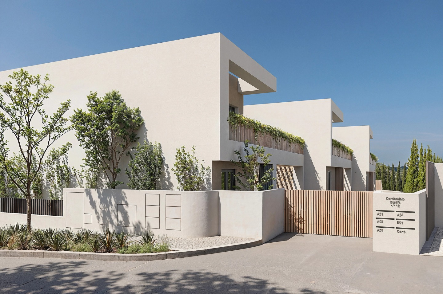 Entrance to the Pearl Villas gated community in Almancil, with white walls, a timber gate and planting.
