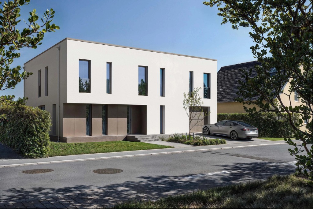 A house of simple lines in Junglinster, white with tall windows and a car parked outside.
