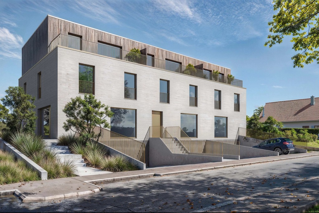 The Jowi building in Frisange, in light brick and timber, with a roof terrace and a garden down to the street.