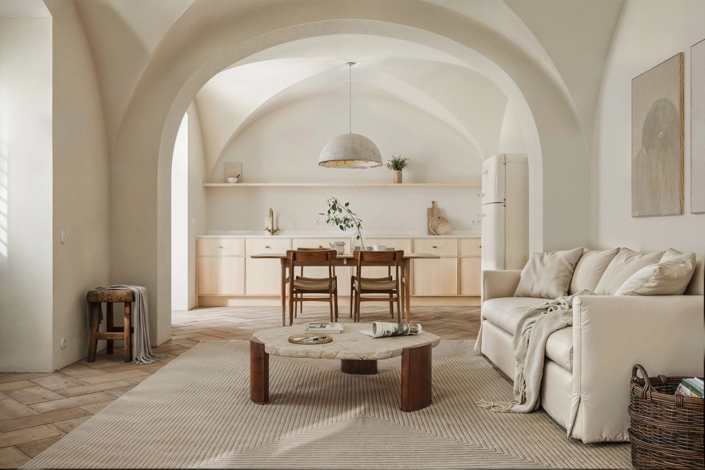 Living room under white vaults with the kitchen beyond, dining table and sofa, at N6 in Boliqueime.