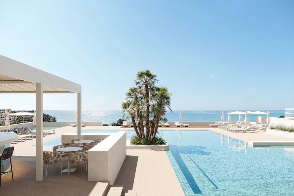 Wyndham Grand Carvoeiro pool with a pergola, palm trees and sun loungers facing the sea.