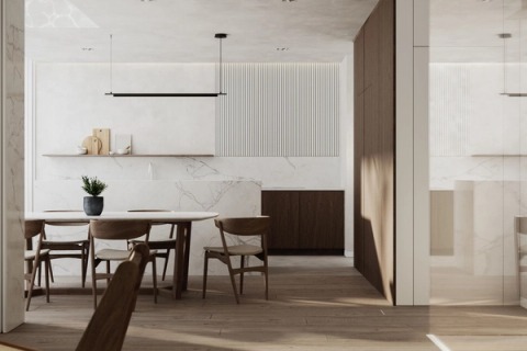 Dining area with an oval table and a marble kitchen with a fluted panel.