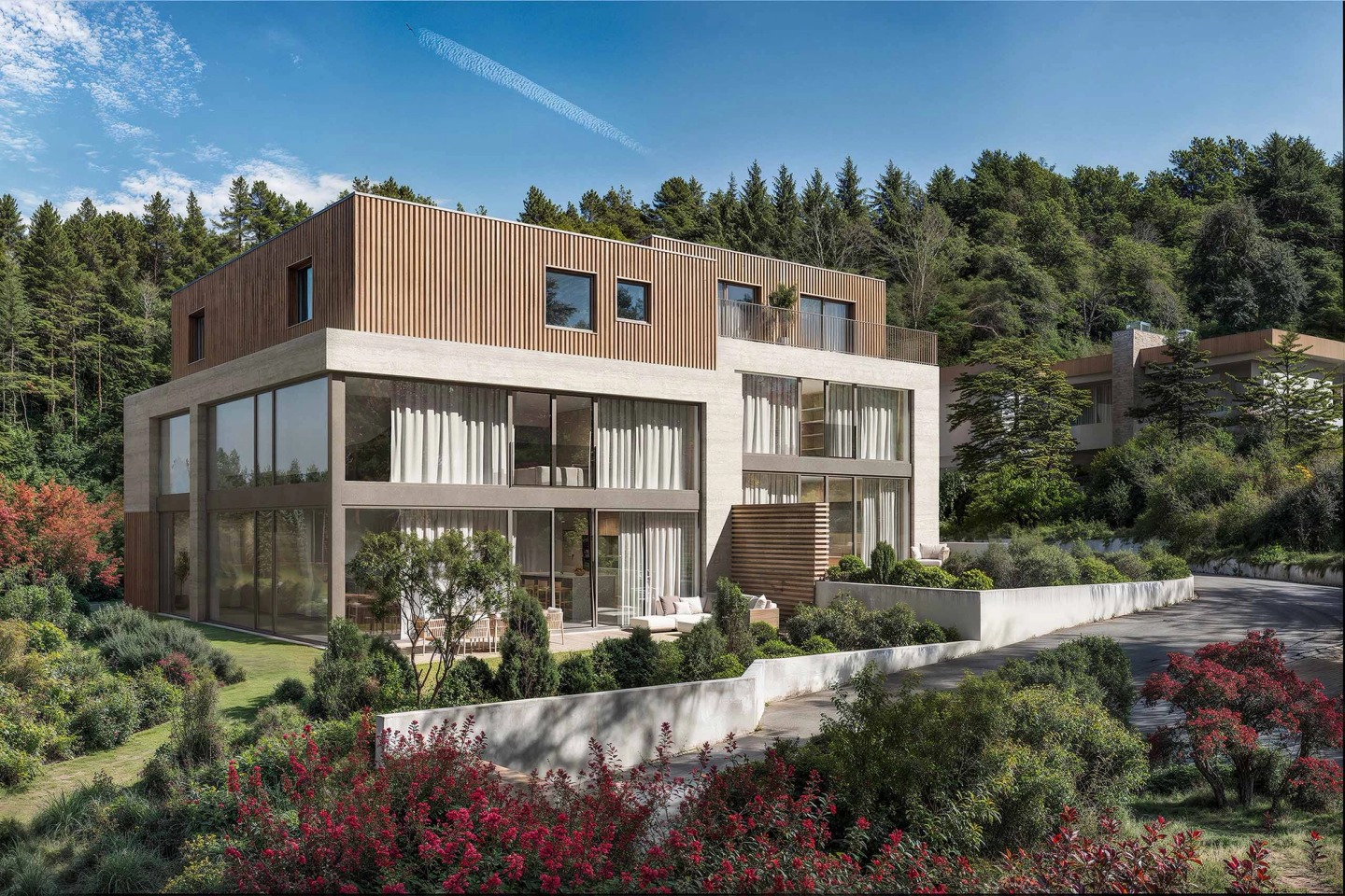 Joho set into the slope of a wooded plot, with wide windows and a terraced garden.
