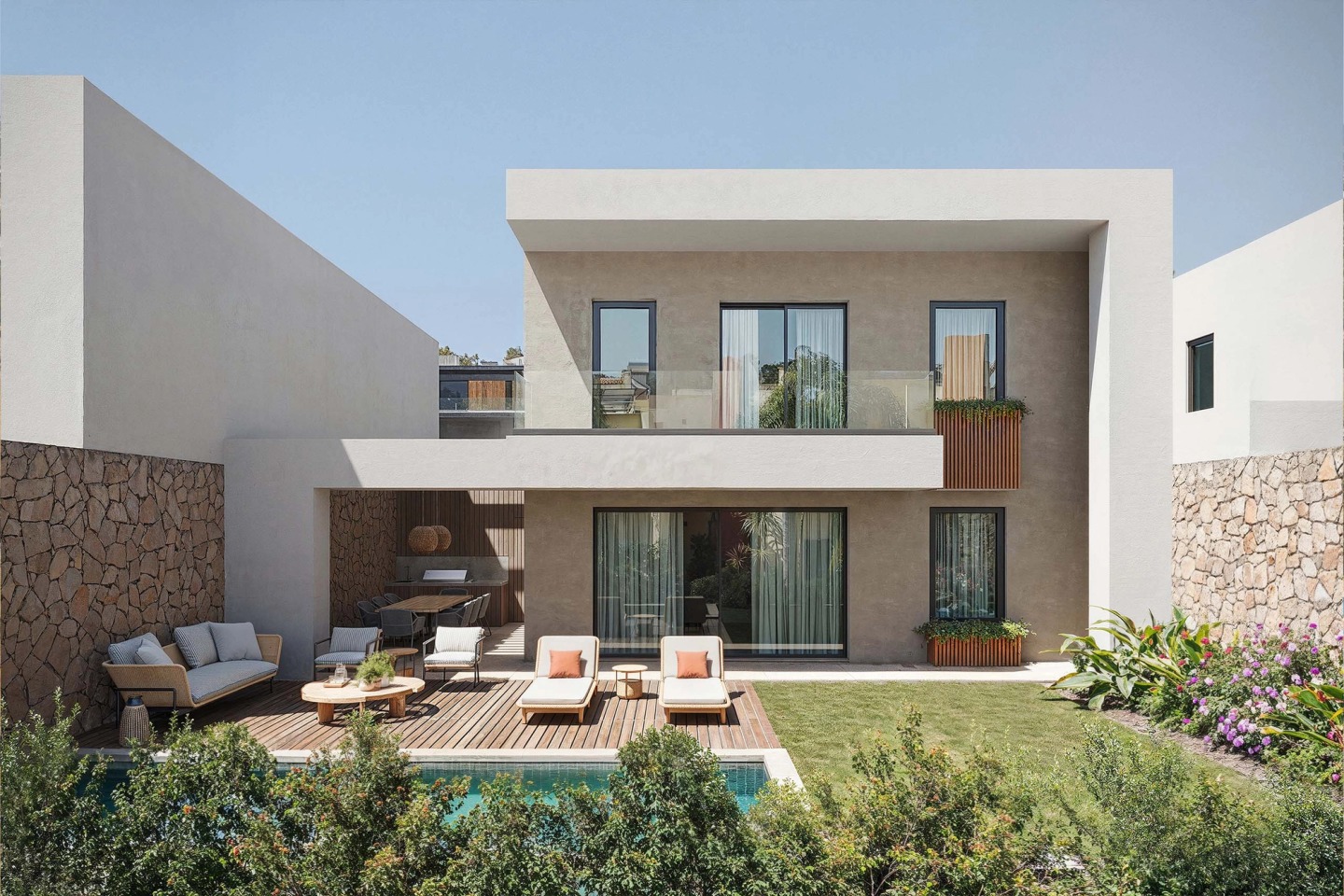 Back of a Pearl Villas house with a pool, timber deck, sun loungers and covered terrace.