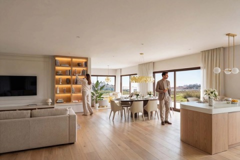 Open-plan living room with an island kitchen, dining table and lit shelving.