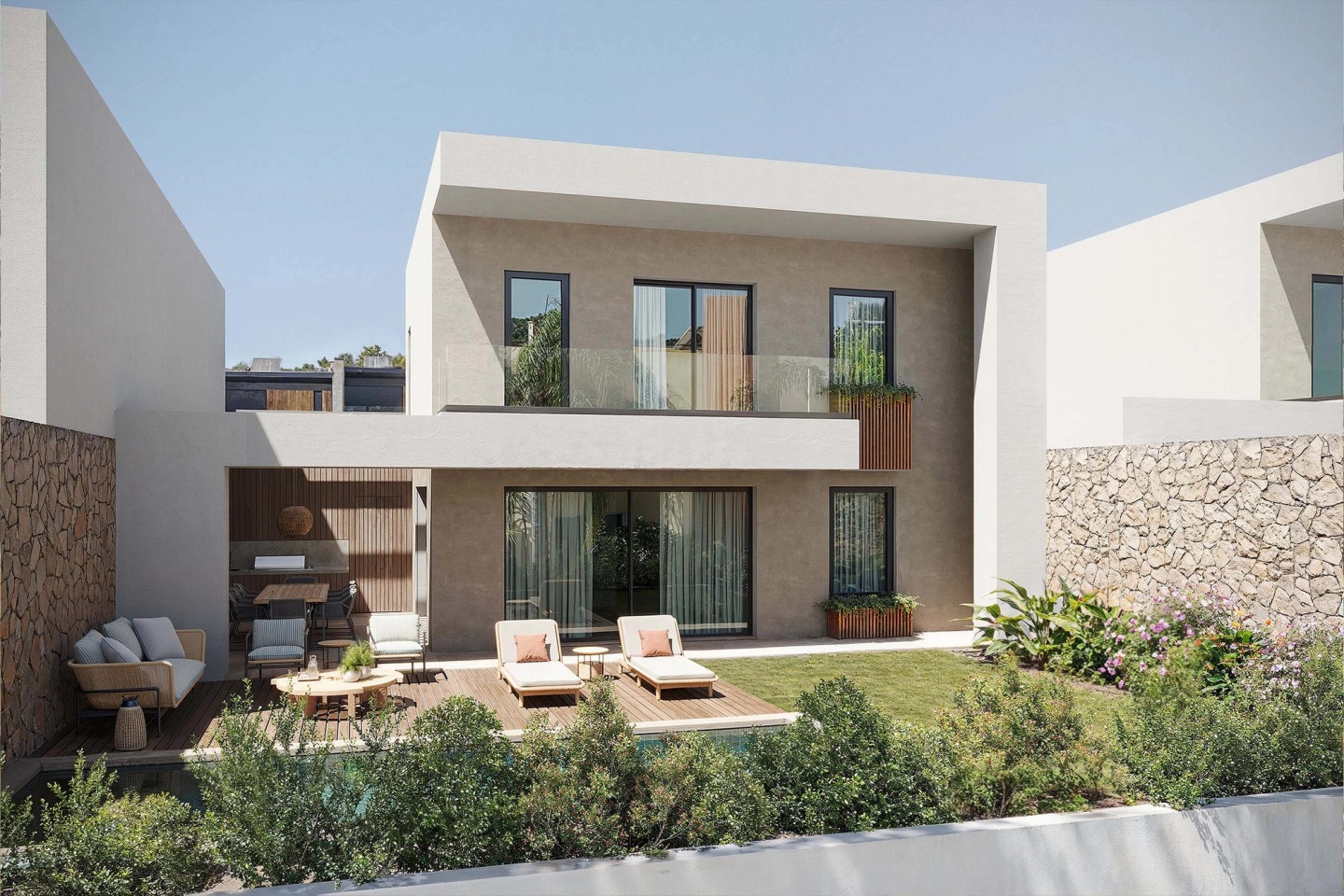 A Pearl Villas house seen from the garden, with a deck, sun loungers and stone walls.