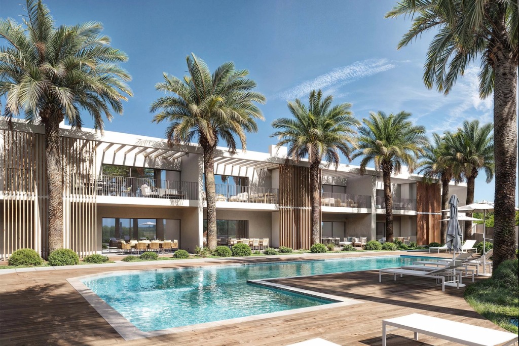 The Oásis pool in Boliqueime surrounded by palm trees, with the apartments and balconies around it.