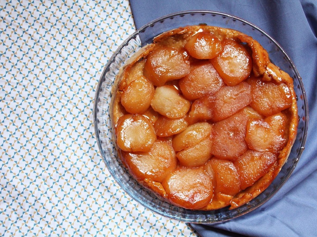 An unmoulded tarte tatin with glossy caramelized apples.