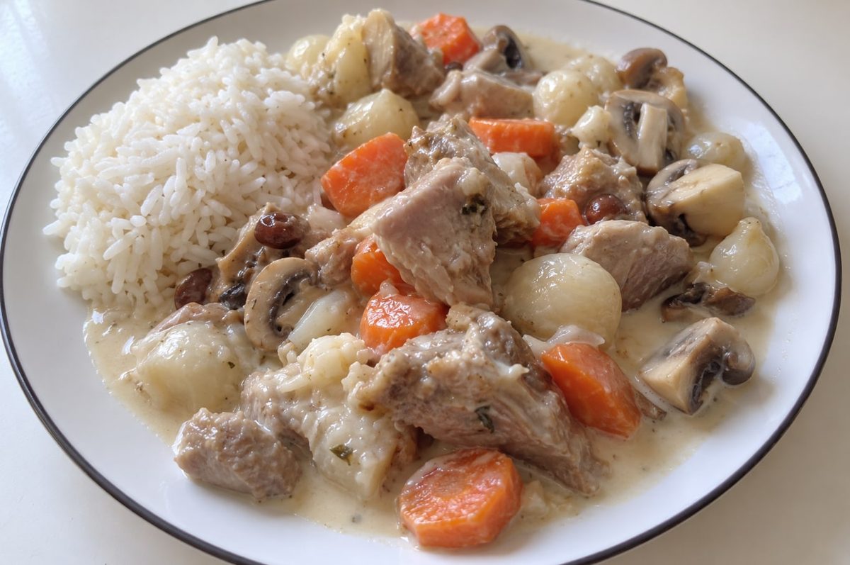 Blanquette de veau with carrots, mushrooms and pearl onions in a creamy white sauce, served with rice.