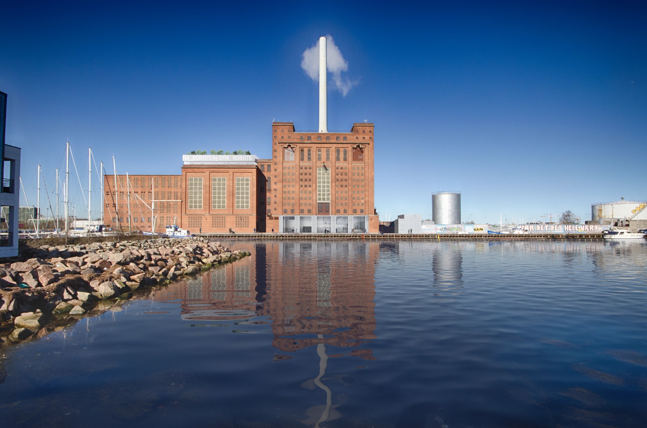 Luftudsigt over havneområde med marinaer, bygninger, jernbane og fodboldbaner