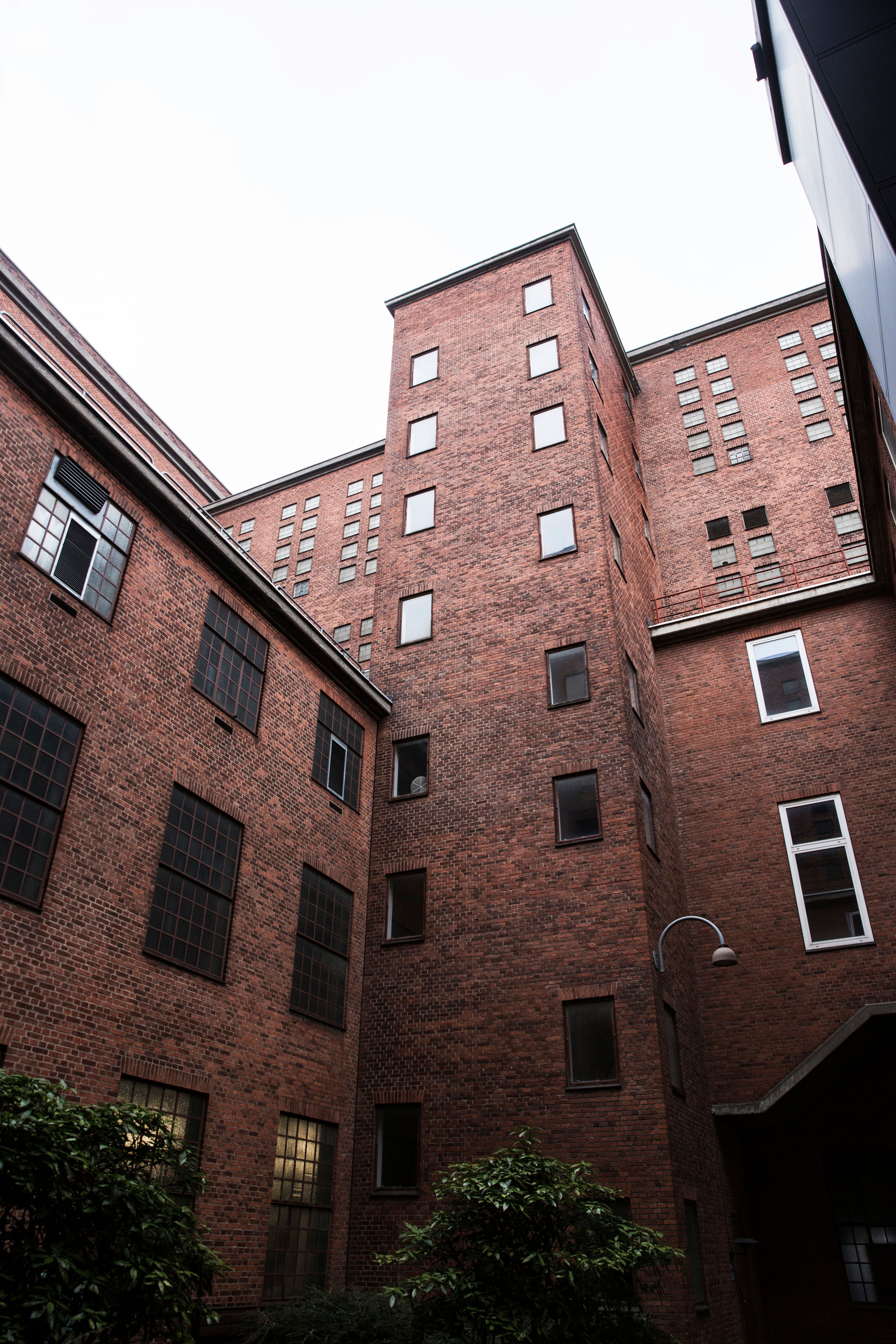 Preview of: Høje røde murstensbygninger med mange vinduer omkring en gård