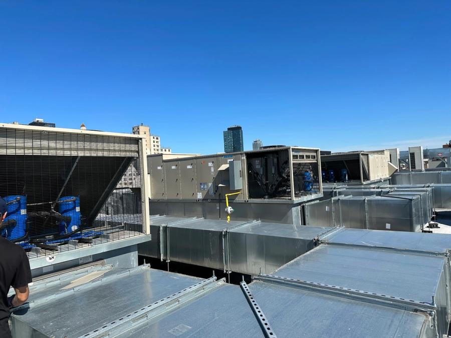 Rooftop air handling unit with sheet-metal supply and return ductwork on a New York City building roof