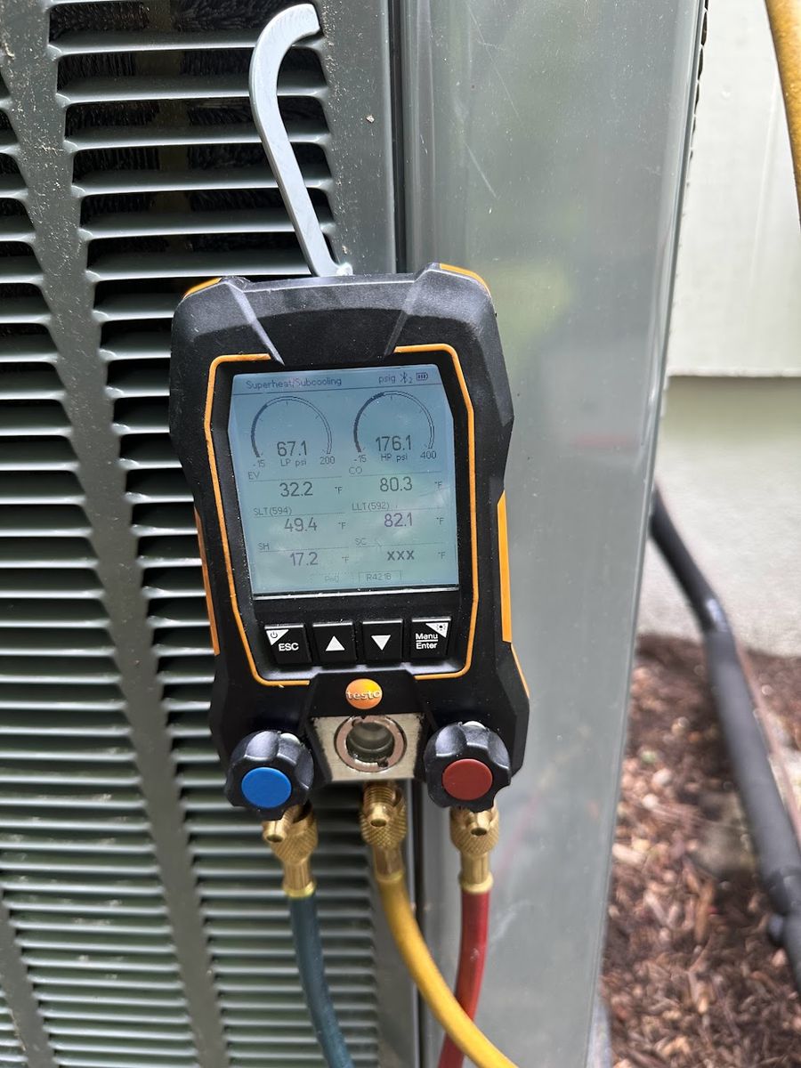 Digital manifold gauges reading suction and discharge pressures, superheat and subcooling on a commercial refrigeration condensing unit