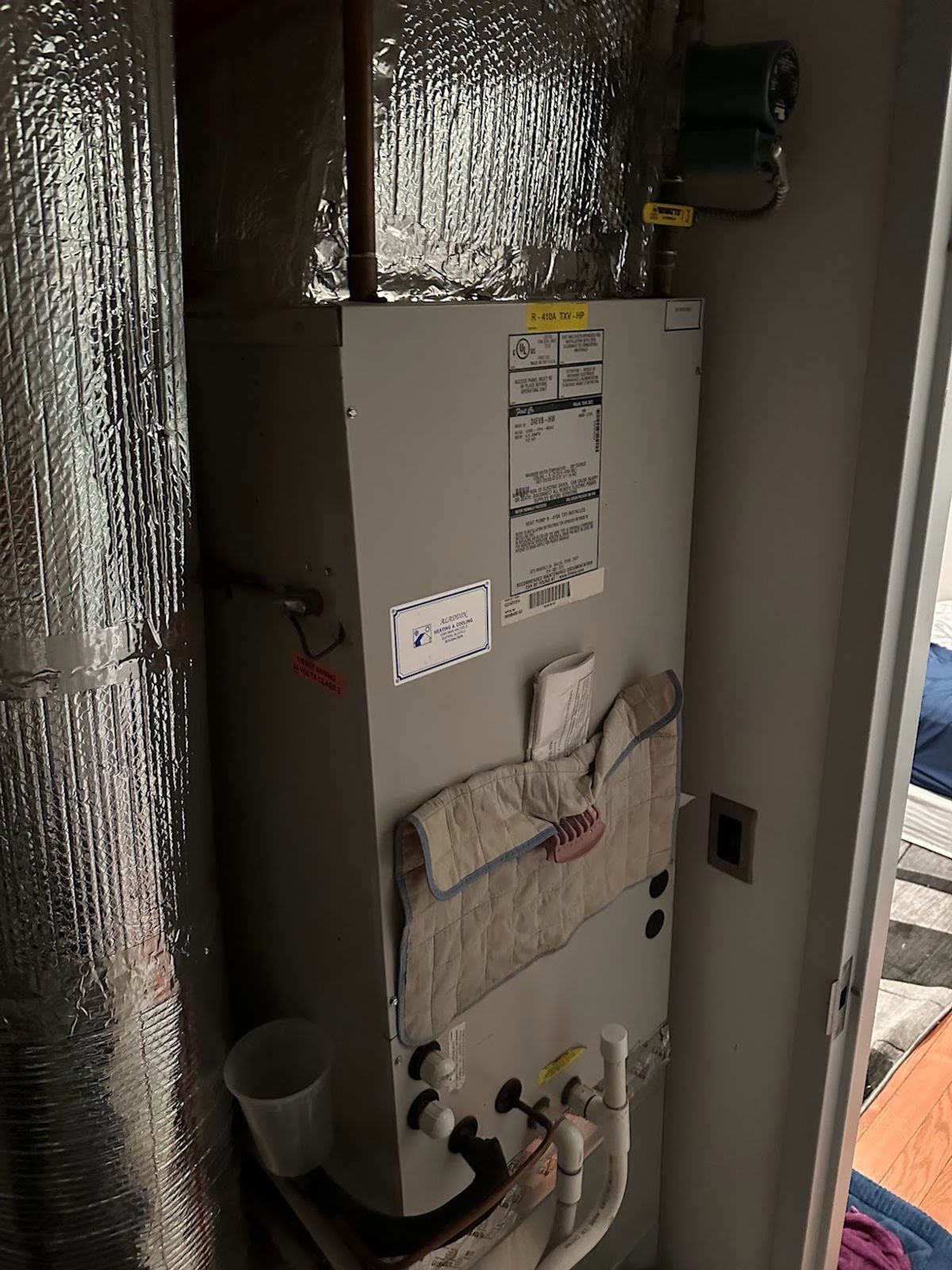 Art HVAC technician installing a complete central heating and cooling system in a NYC home