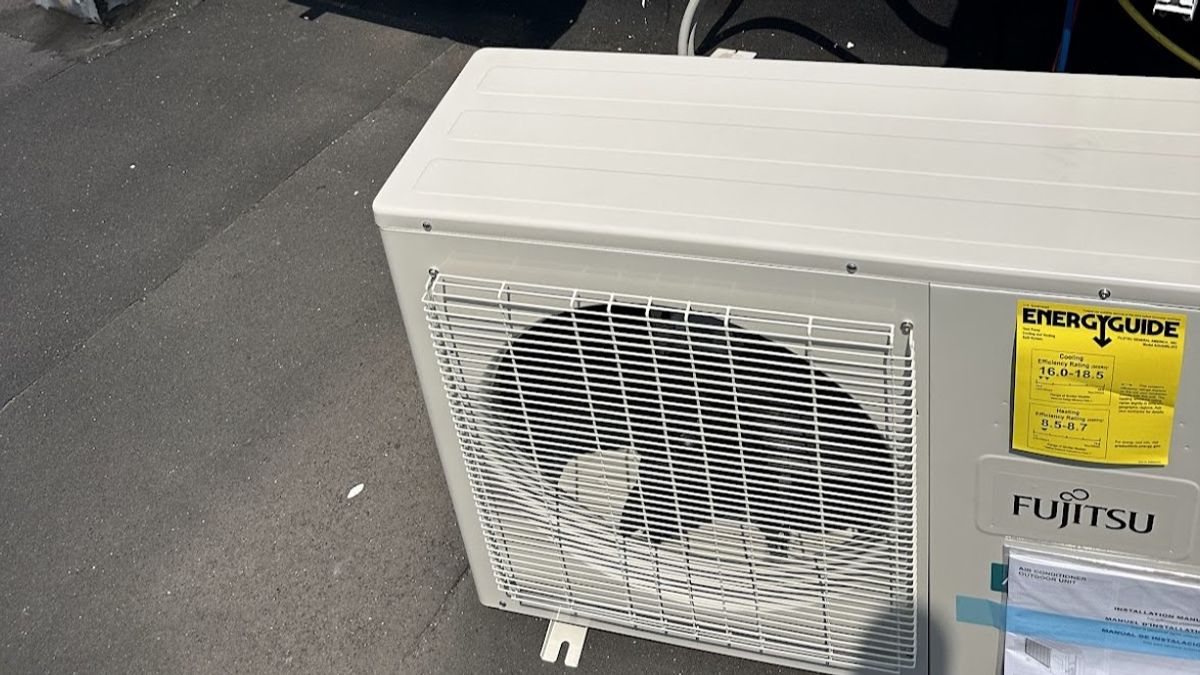 Art HVAC installer mounting a new high-efficiency heat pump outdoor unit at a NYC brownstone