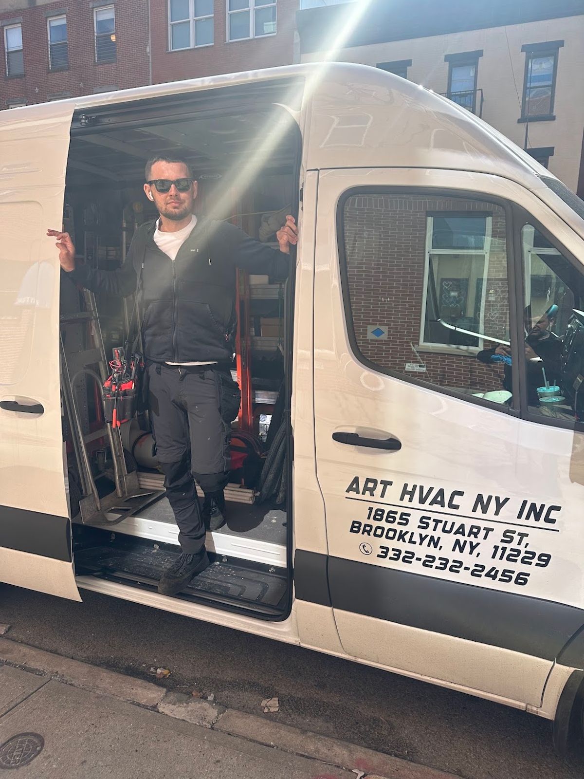 Art HVAC NY service van on a Brooklyn street with a technician stepping out for a service call