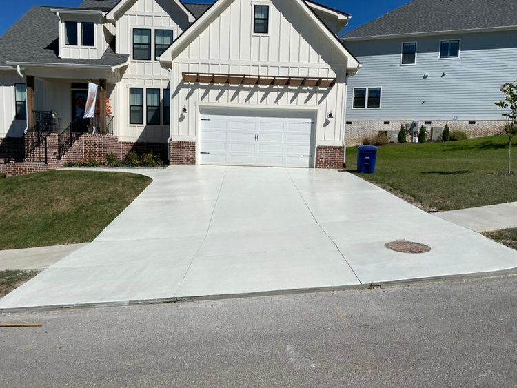 Curved concrete driveway with landscaping