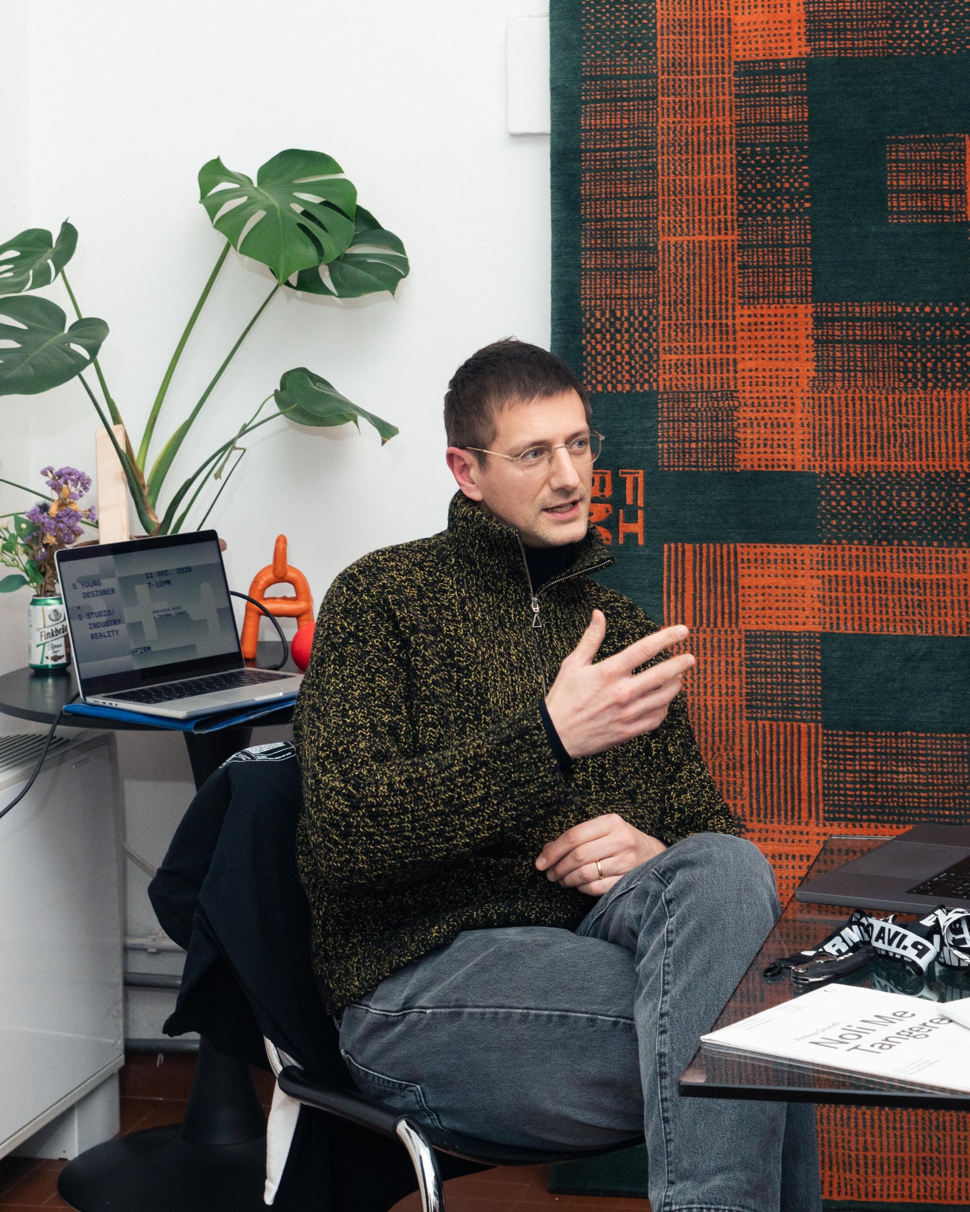 5+1 participant speaking beside a laptop in the Firm studio.