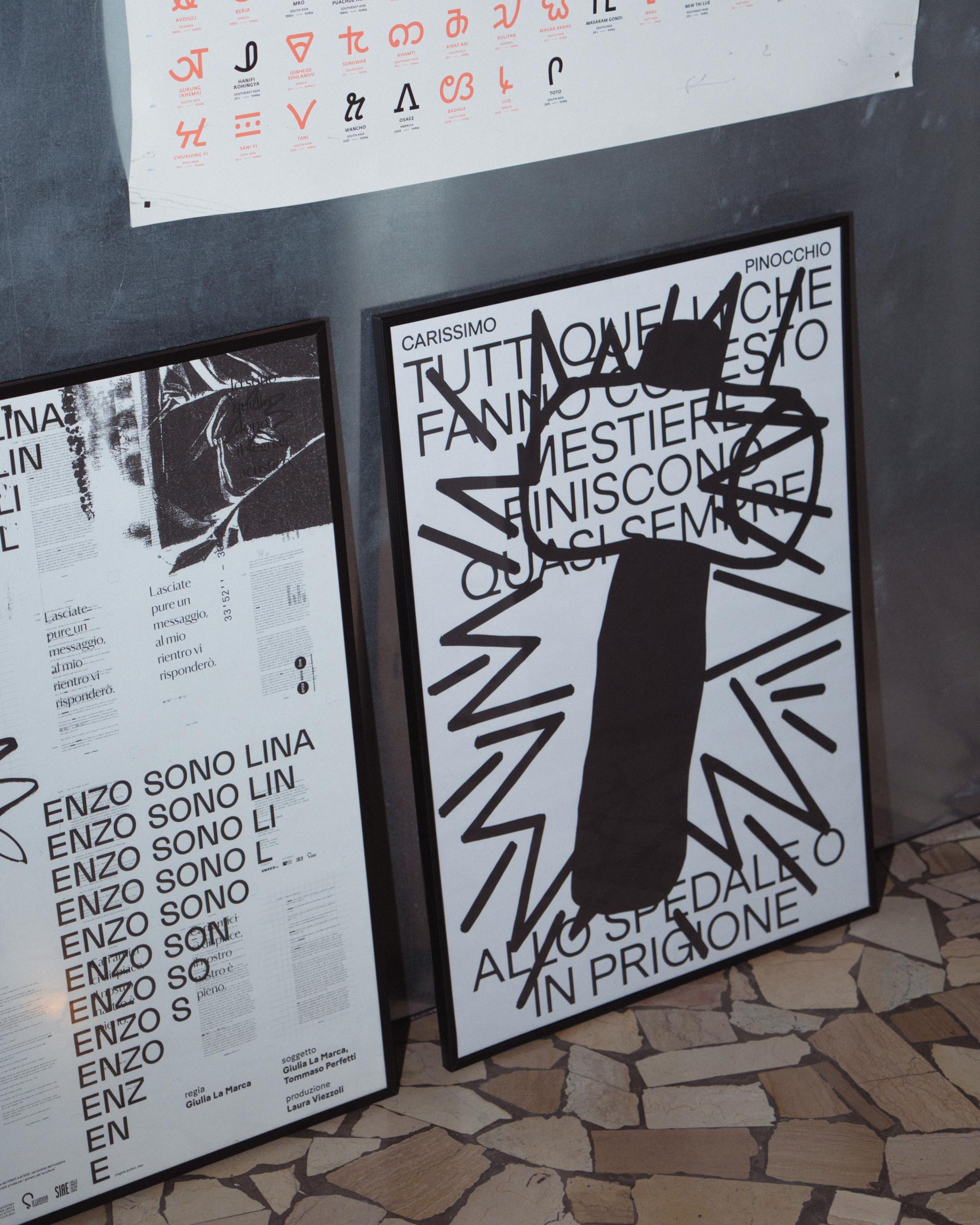 Two framed typographic posters leaning against a wall.