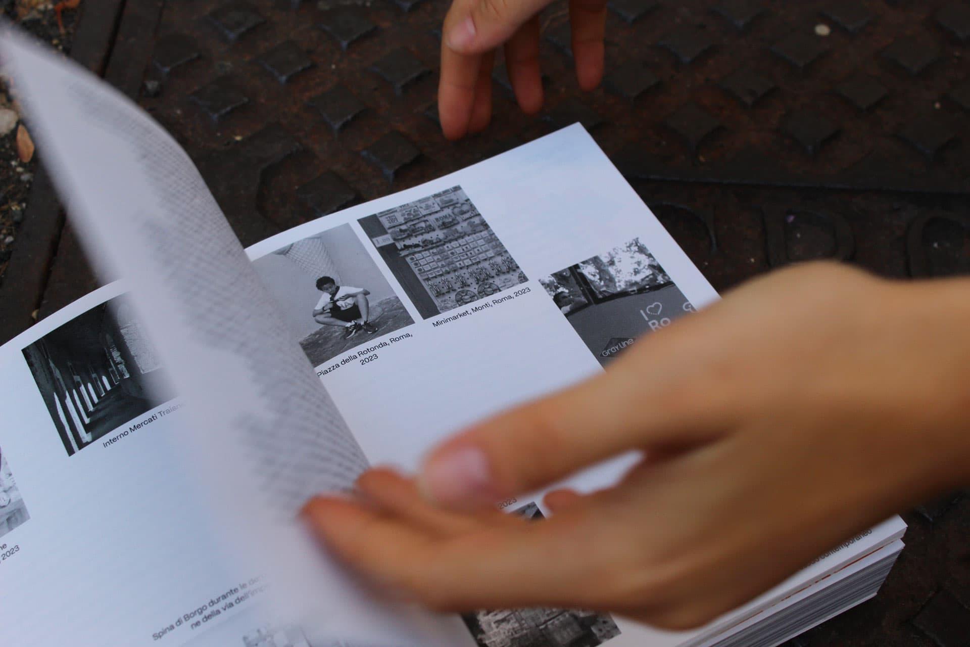Hands turning a Stato in Luogo book page with black-and-white archival photographs.