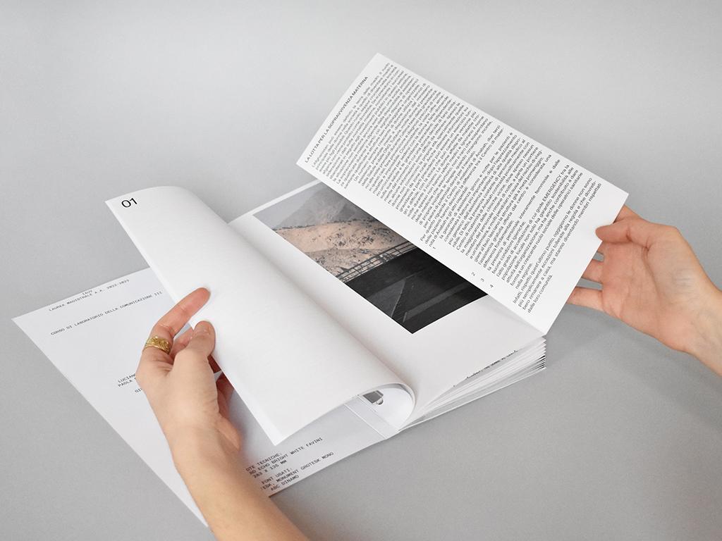 Hands opening the Brick by Brick publication to a page with a documentary photograph and text.