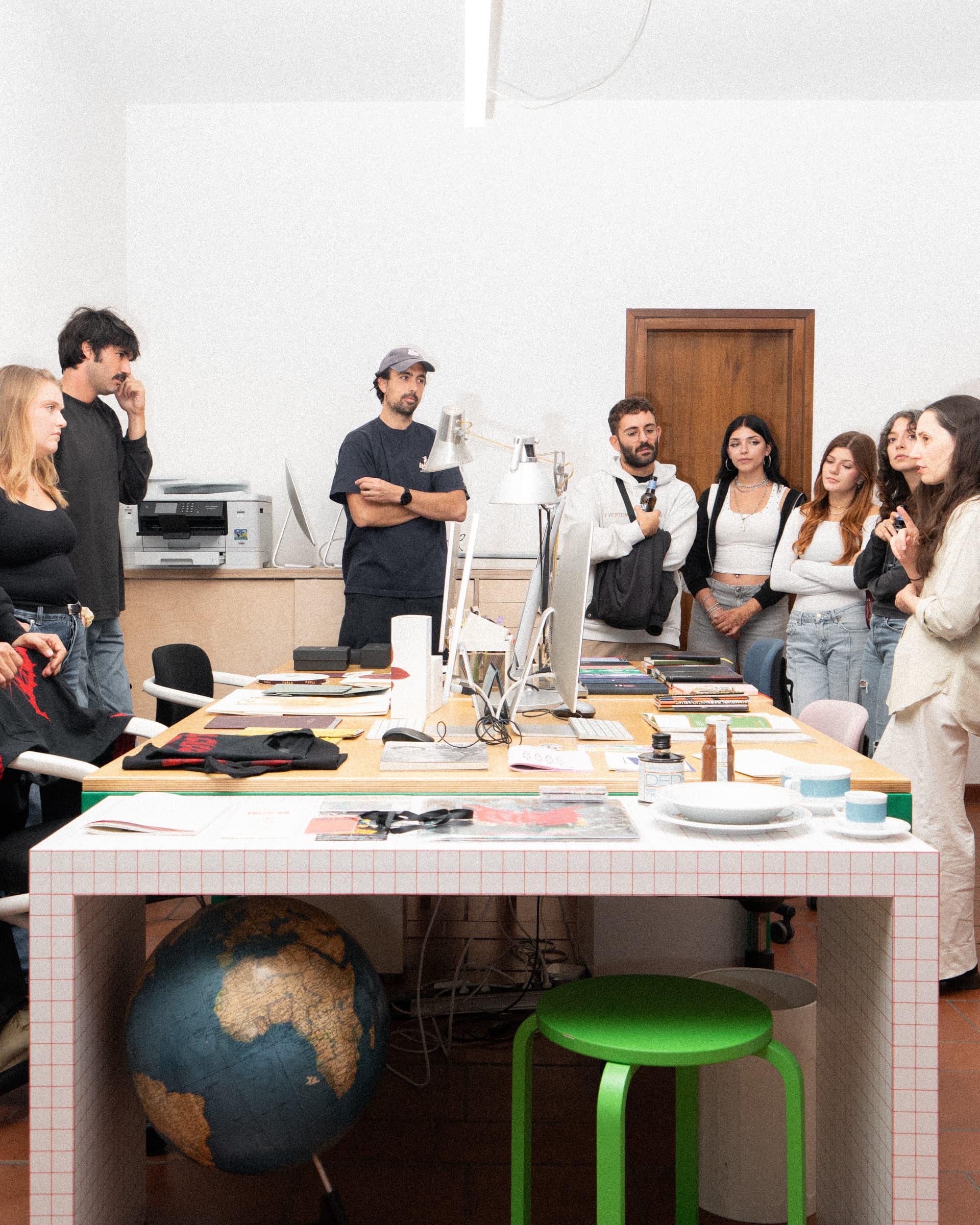 Attendees standing around a worktable in the Ascionemagro studio.