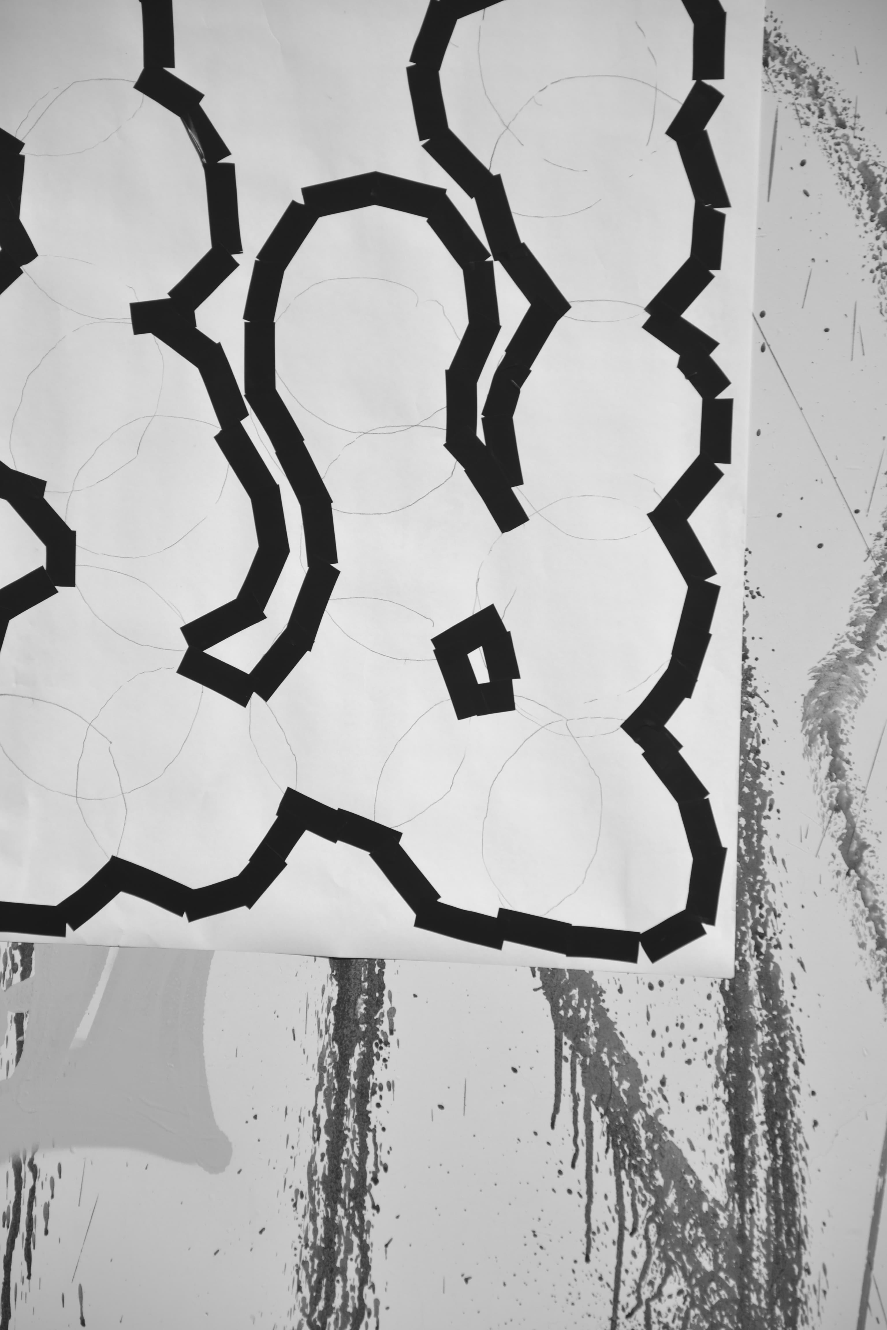 Close-up of a white print with bold black abstract lettering.