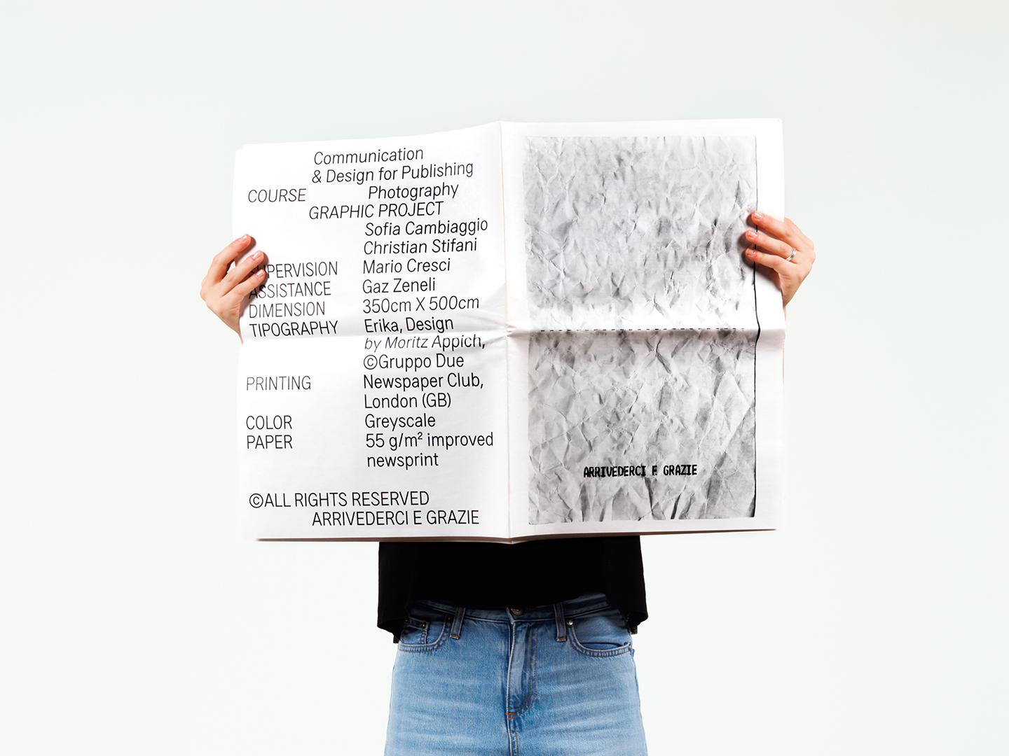 Person holding a large white printed poster in front of their face.