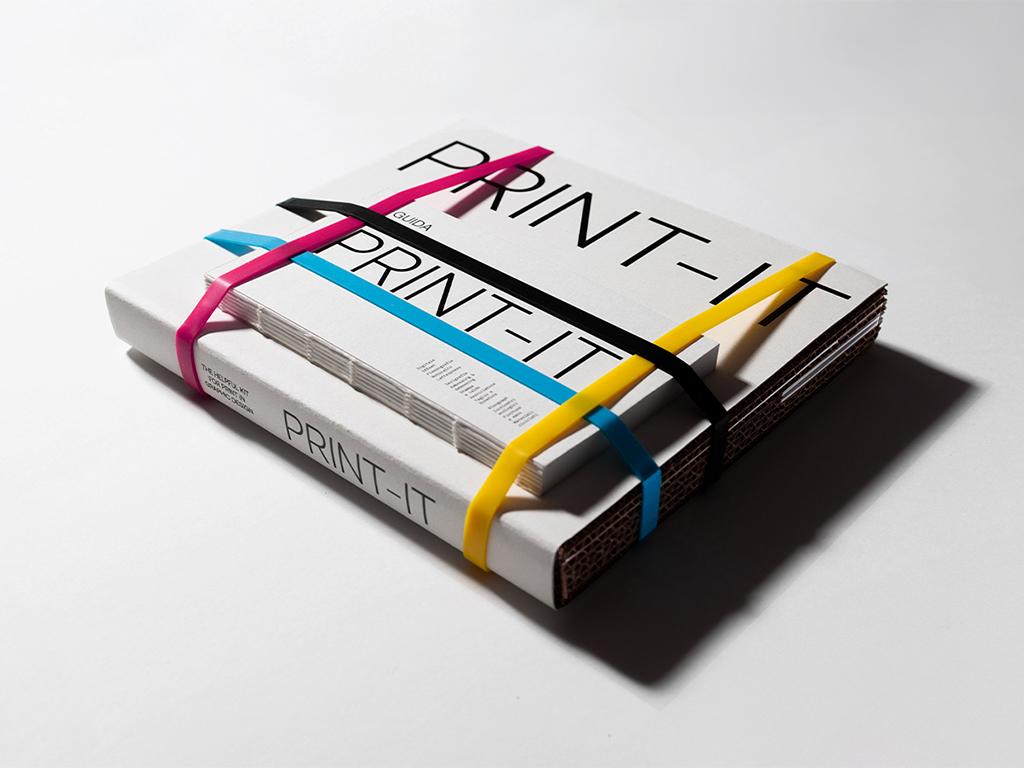 Stack of Print-It books held with pink, yellow and blue elastic bands.