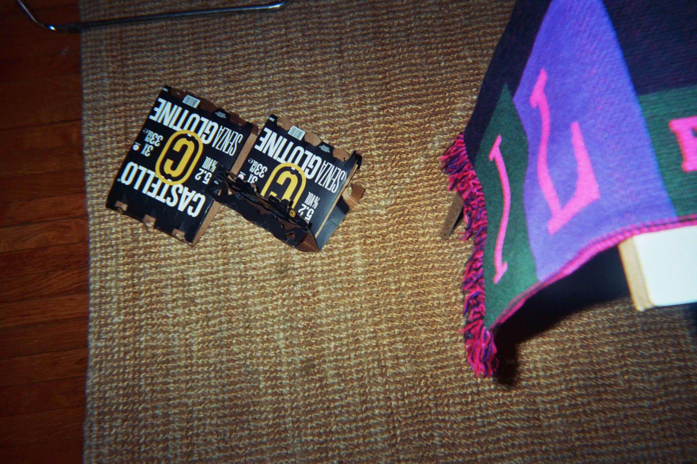 Two Castello Senza Glutine beer packs beside a purple and green patterned textile.