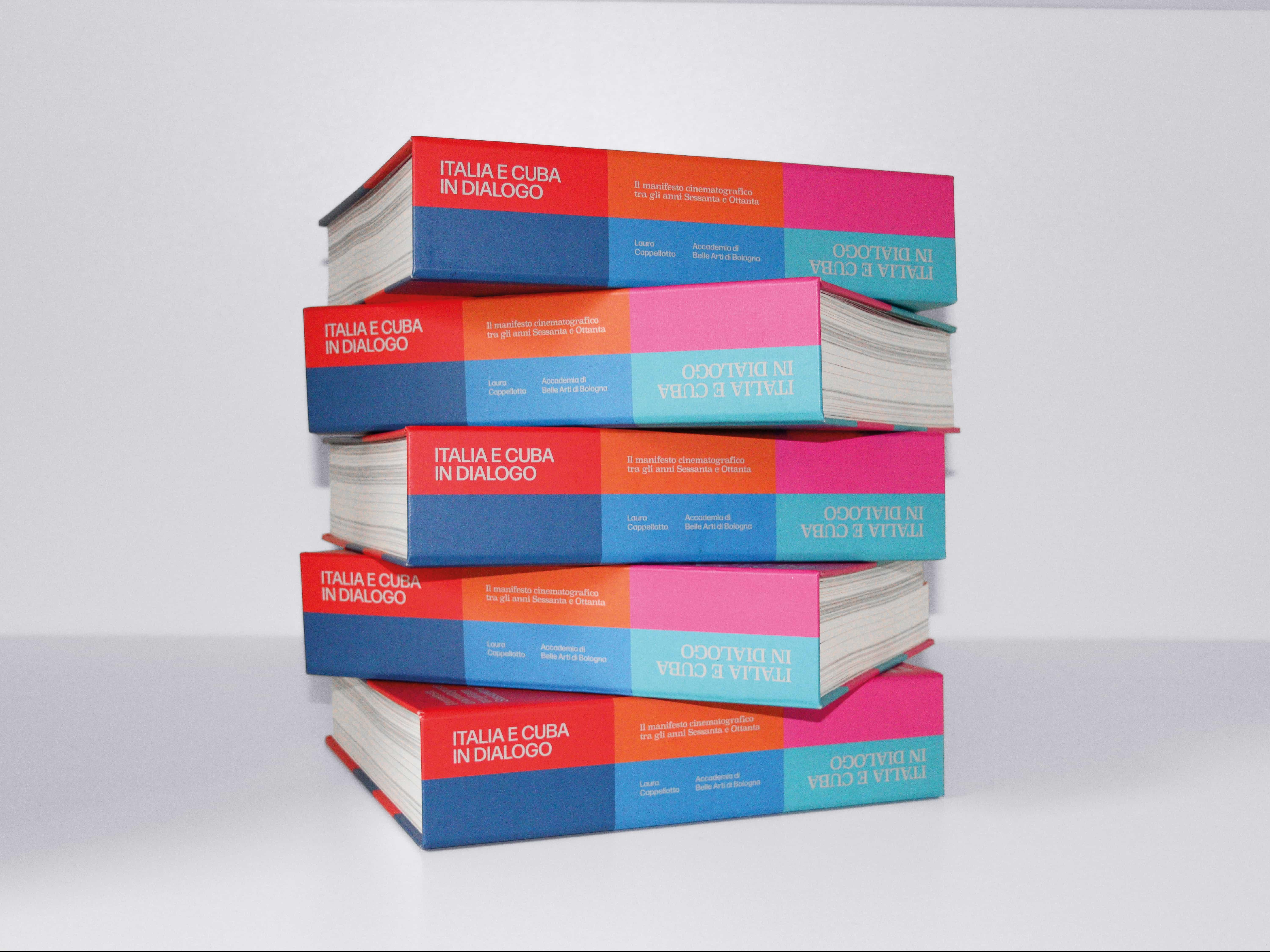 A stack of five copies of Italia e Cuba in dialogo on a white surface, their colour-blocked spines facing out.