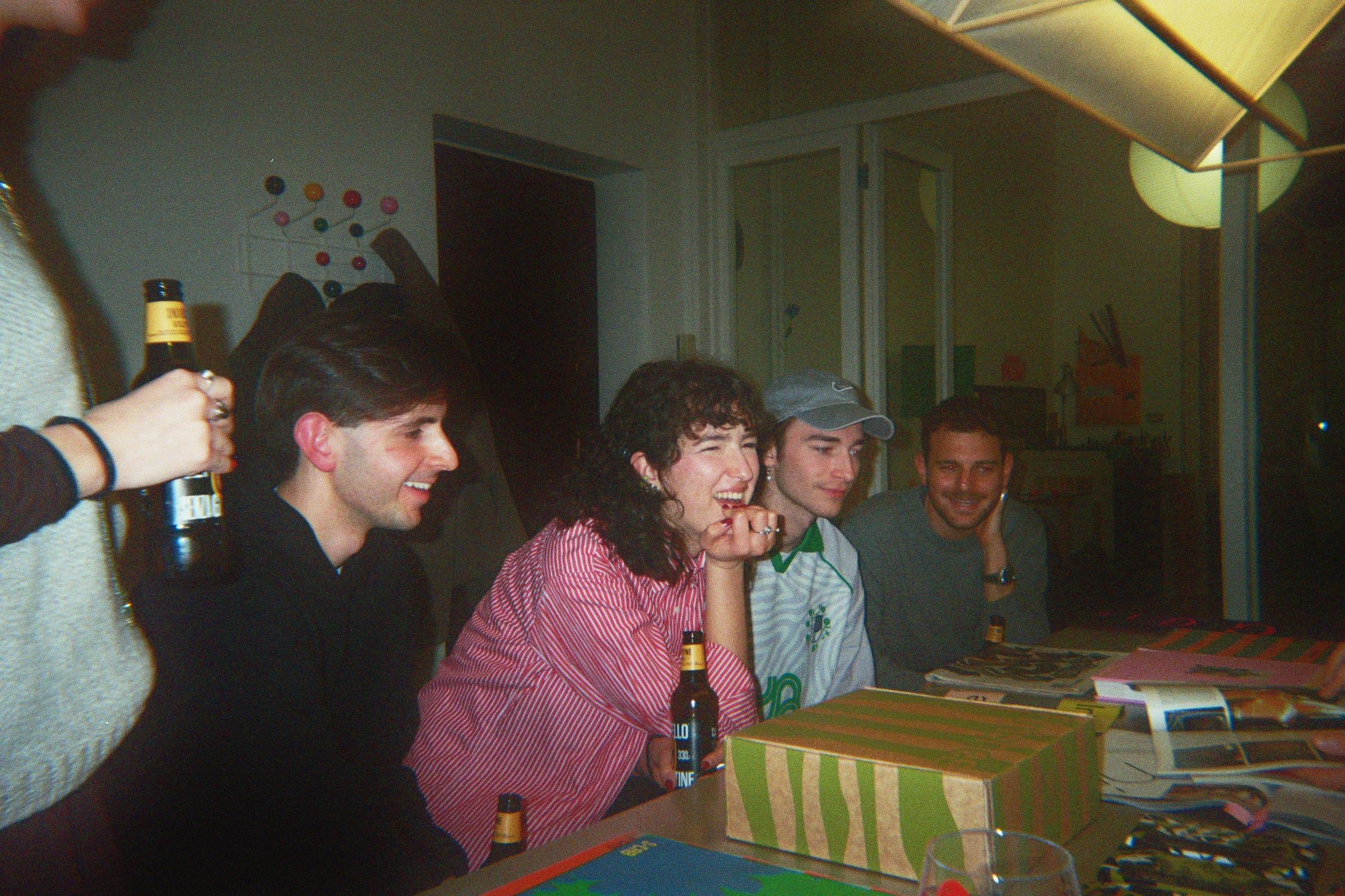 5+1 attendees seated at a LaTigre worktable with books, printed work and Castello beer.