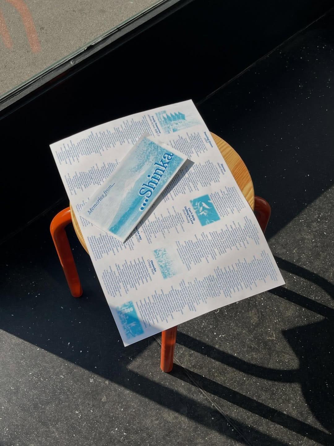Shinka type specimen sheet on a wooden stool, printed by Atelier Tatanka.