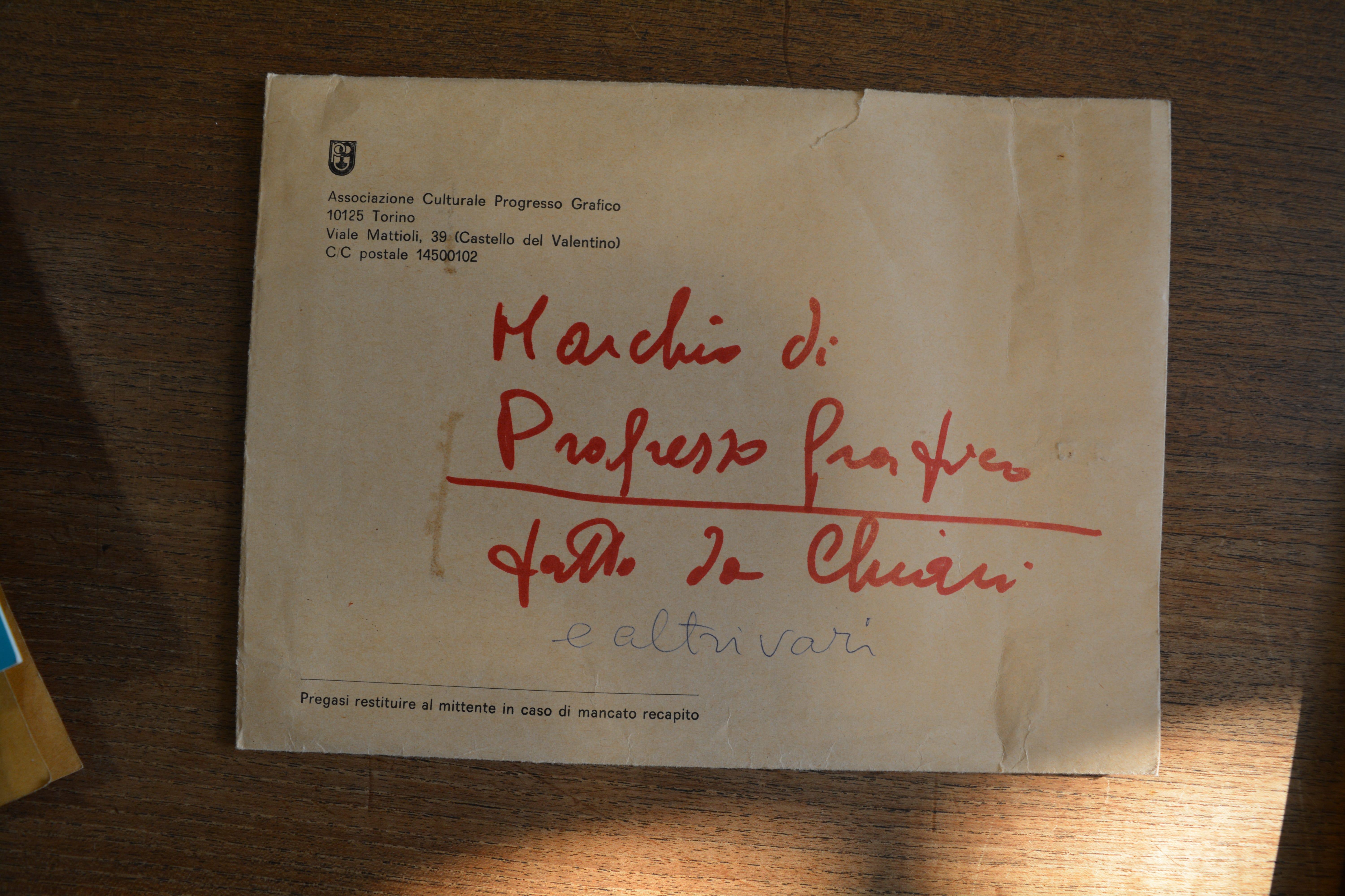Close-up of a printed envelope on a wooden table at the Library of the Politecnico di Torino.