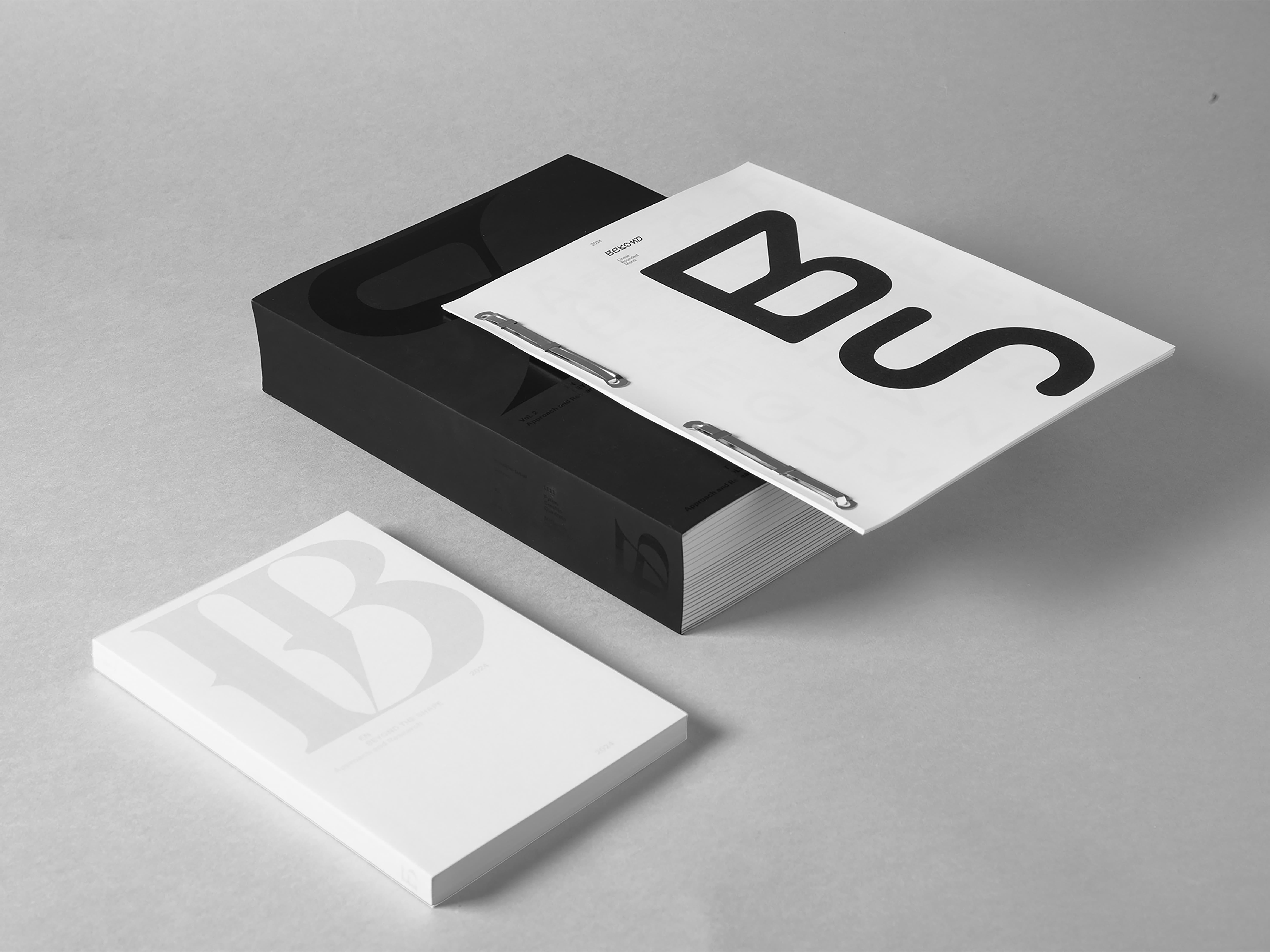 Black and white boxed publications with abstract black shapes.