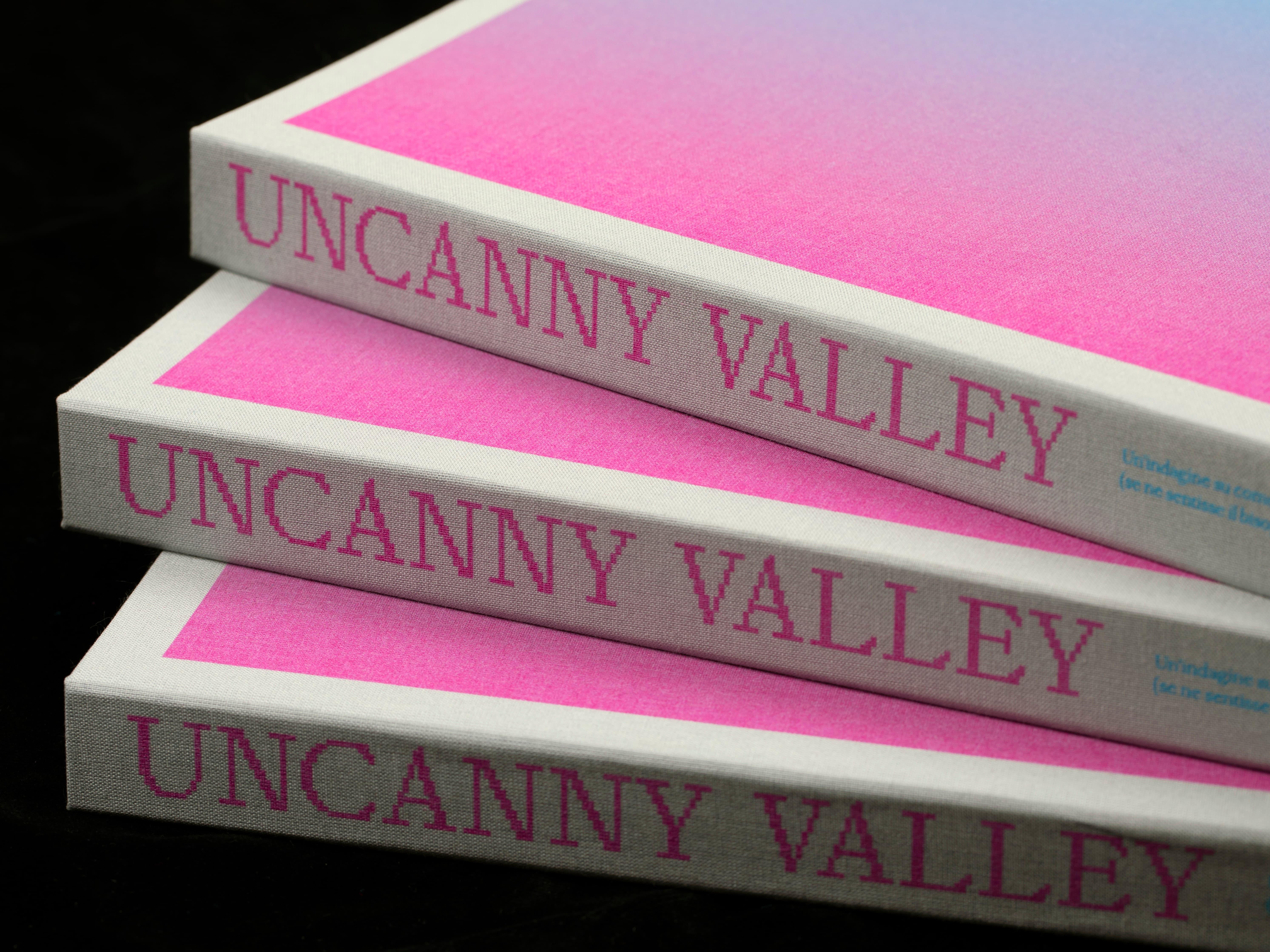 Stack of Uncanny Valley books with bright pink page edges.
