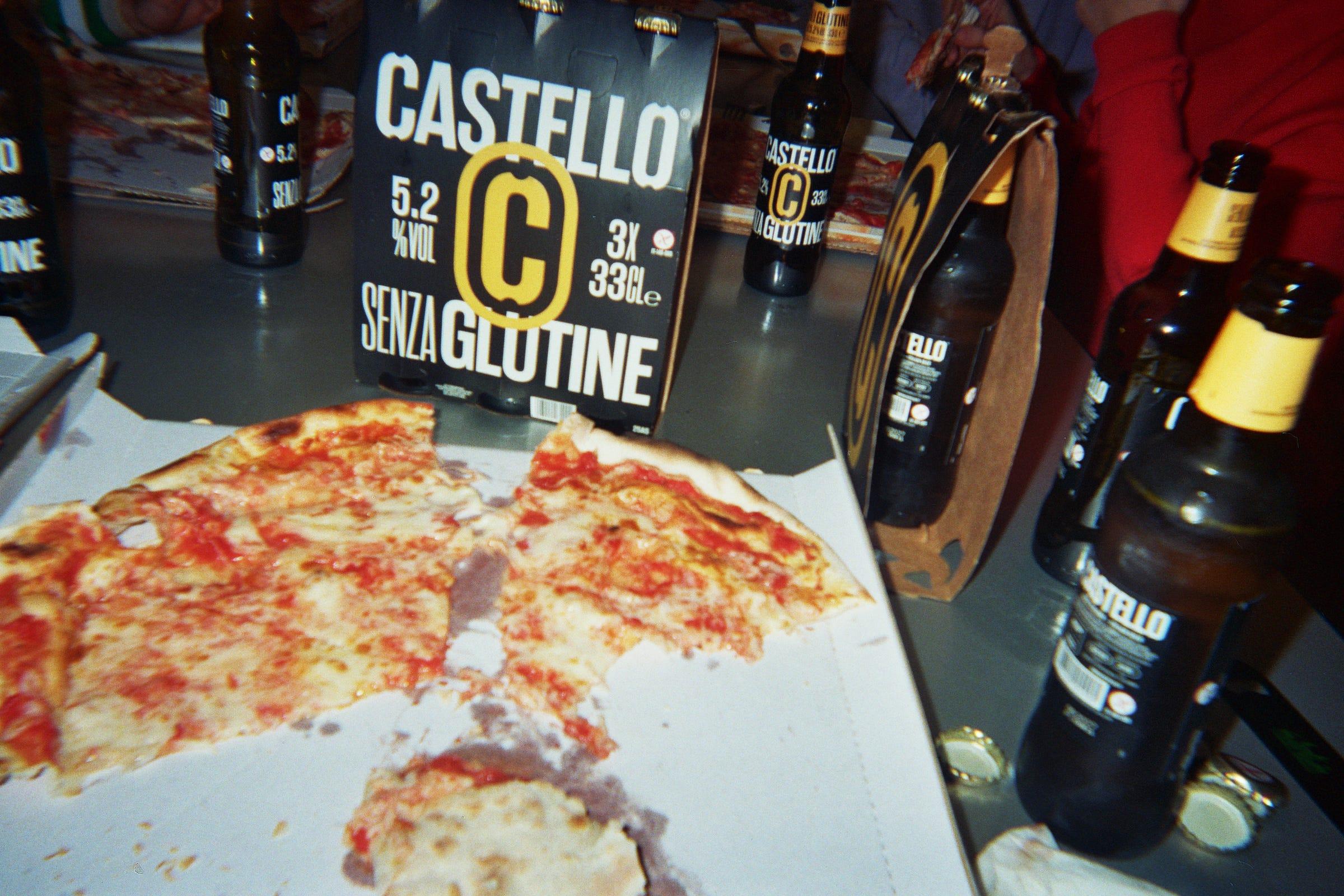 Pizza and Castello Senza Glutine beer bottles on the LaTigre worktable.